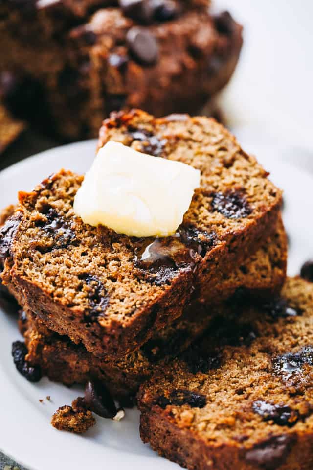 A slice of pumpkin chocolate chip bread with a slab of melting butter