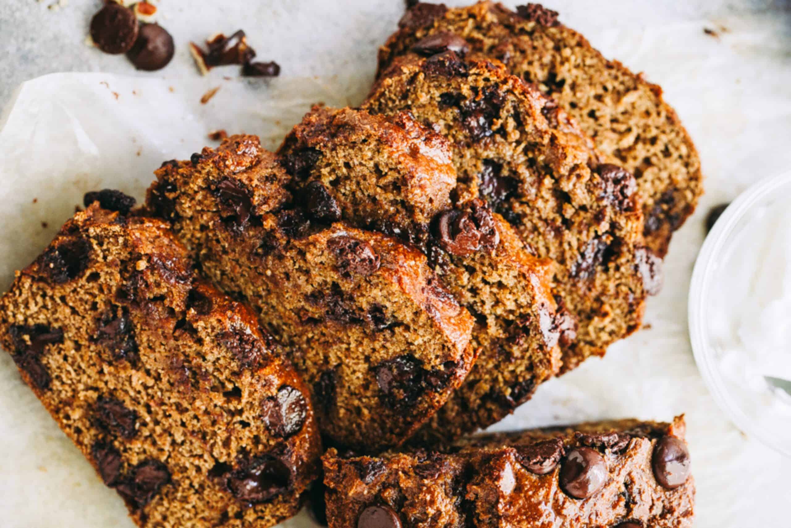 The BEST pumpkin bread recipe for fall! This easy Pumpkin Chocolate Chip bread is packed with warm spices, rich pumpkin flavor, and dark chocolate chips! Sliced chocolate chip pumpkin bread with a moist, spiced crumb and chocolate chips throughout.