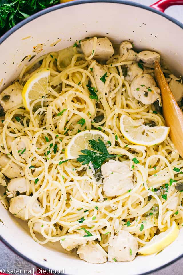 Chicken piccata pasta in a pot with a wooden spoon