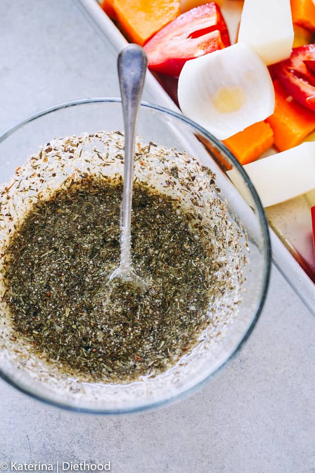 A Bowl of garlic parmesan dressing prepared with balsamic vinegar, herbs, seasonings, garlic, and olive oil.