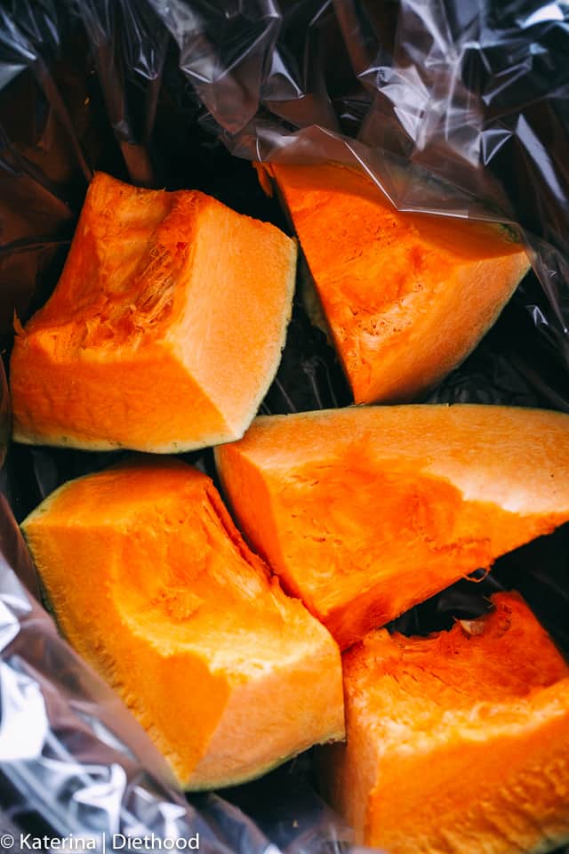 Closeup of pumpkin wedges in a lined slow cooker.