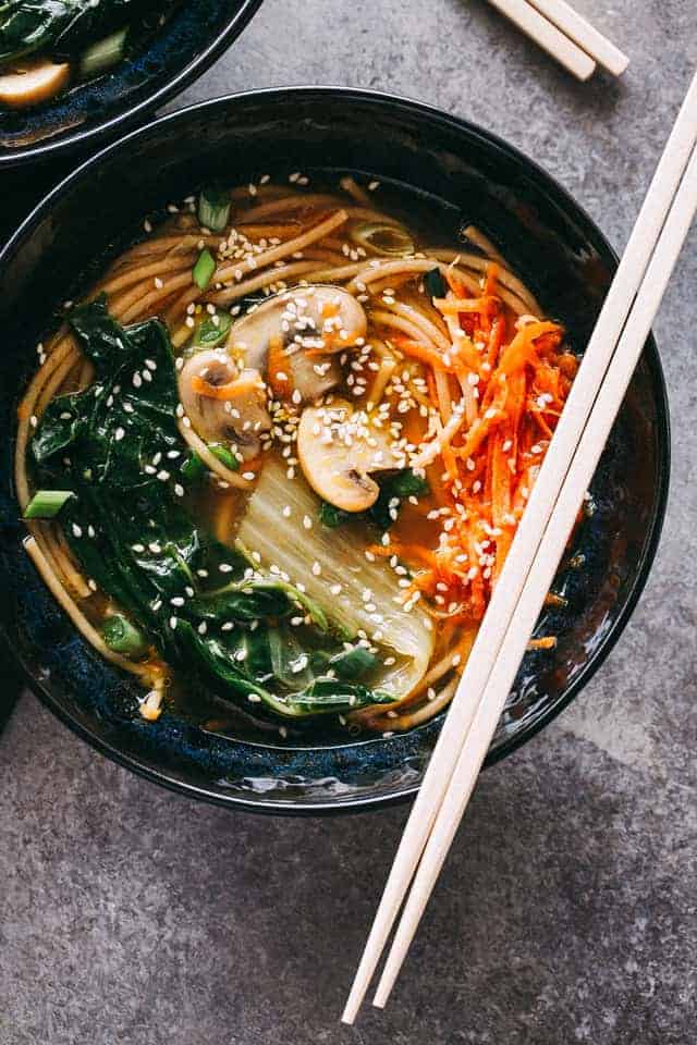 A bowl of soba noodle soup and chopsticks set over the bowl.