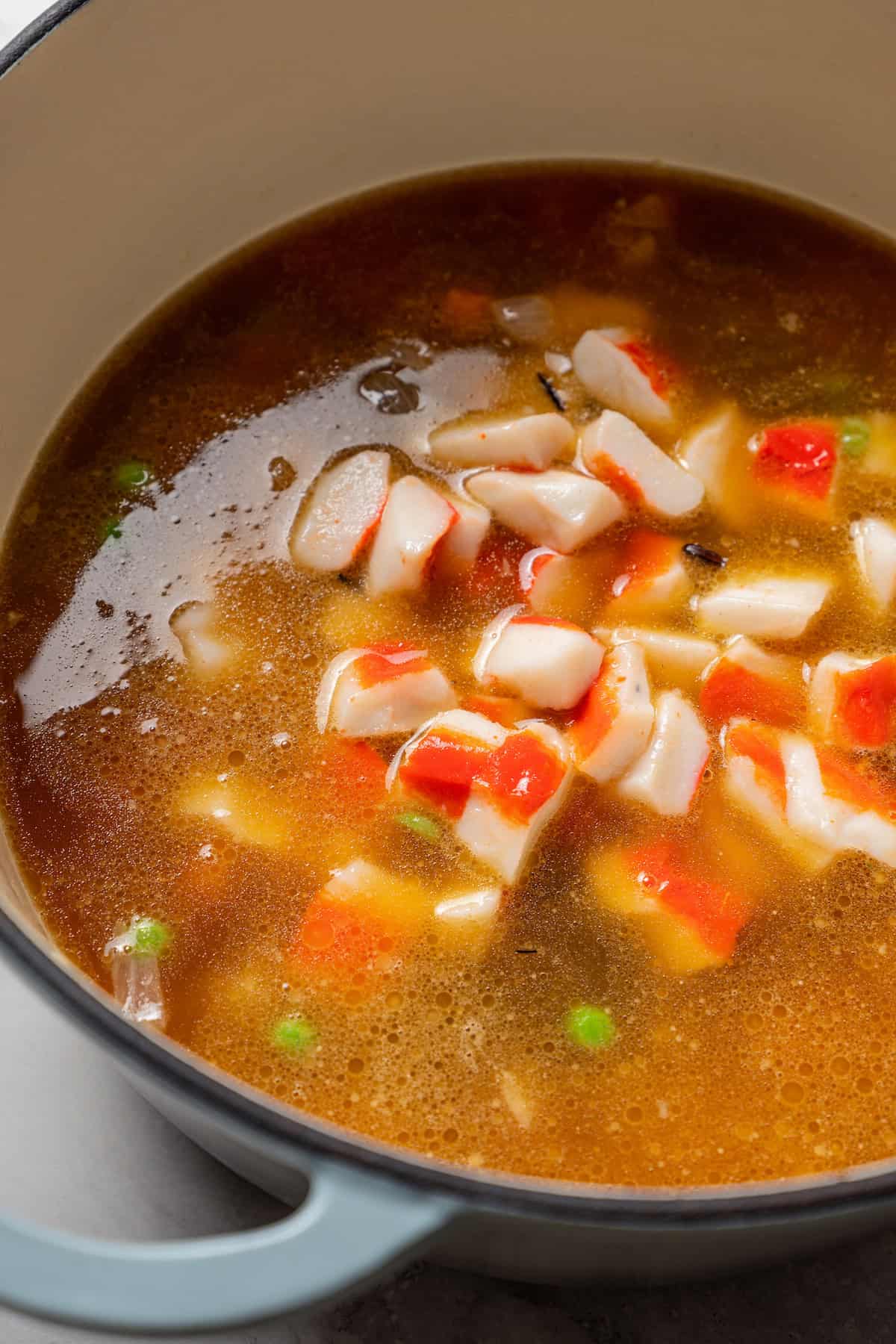 Crab meat added to a pot of broth.