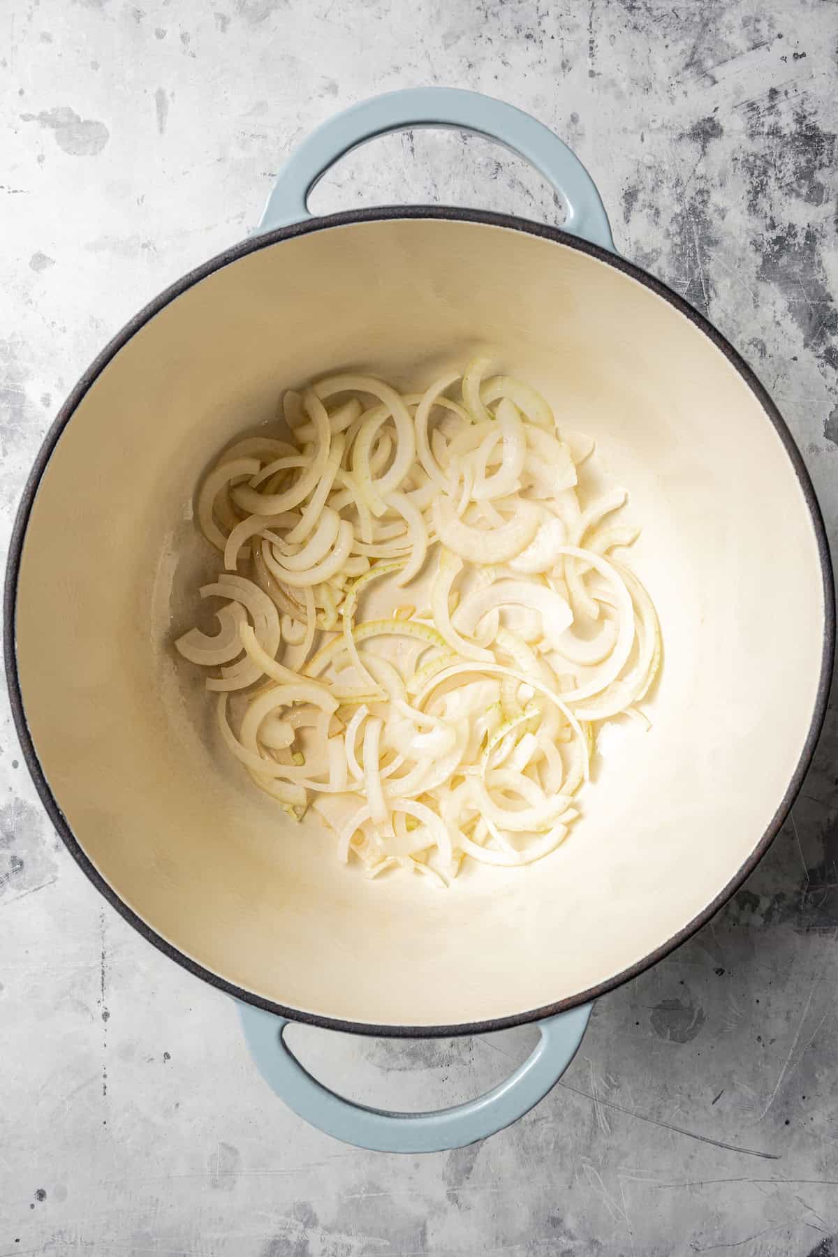 Sliced onions inside a large pot.