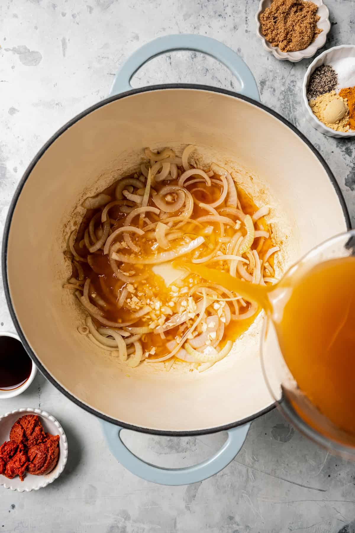 Broth added to sauteed onions in a large pot.