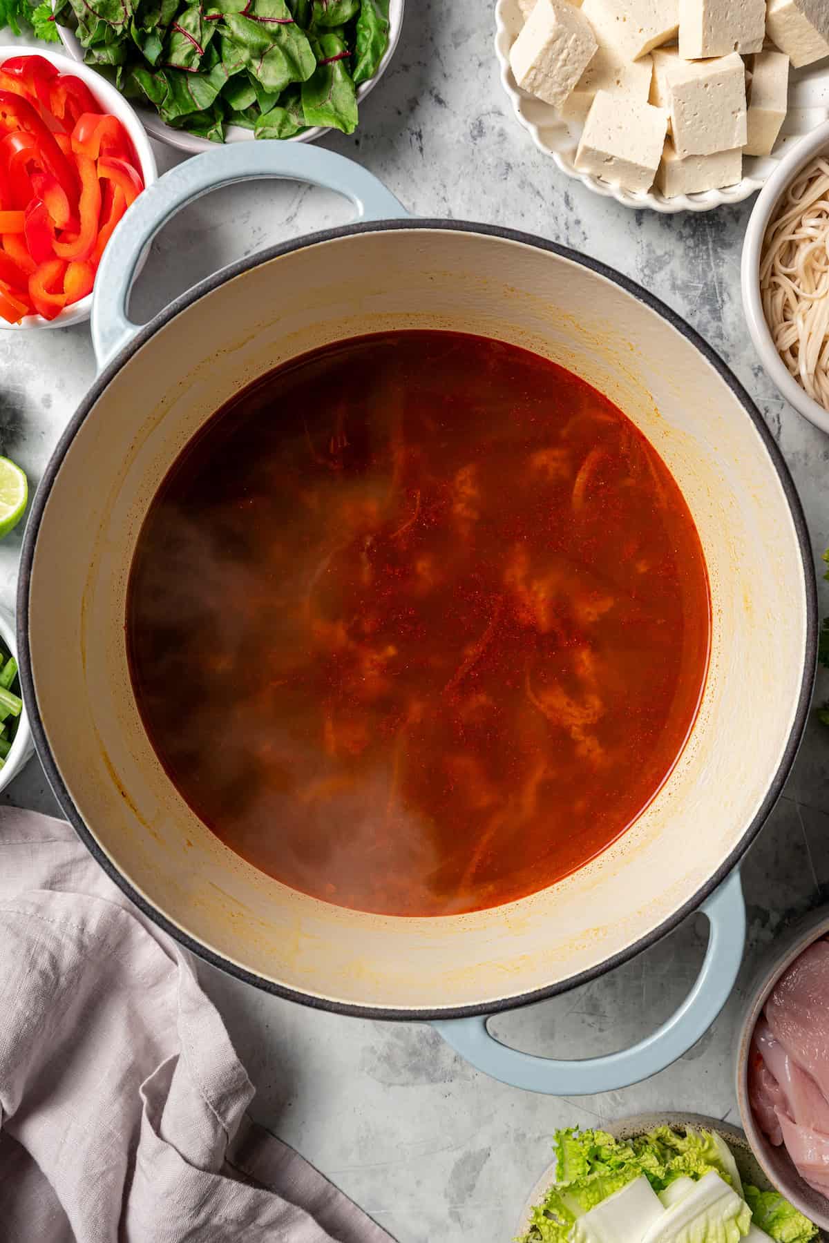 Chinese hot pot broth simmering in a large pot.