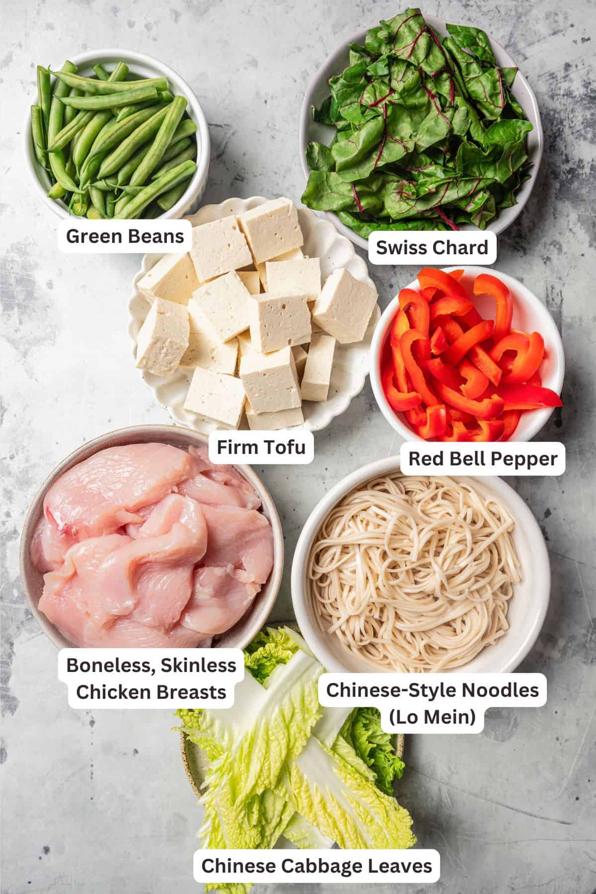 Fresh ingredients for Chinese hot pot with text labels overlaying each ingredient.