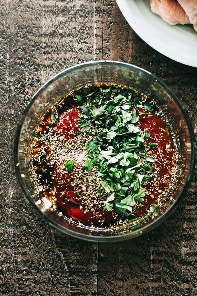 Combining the ingredients for a honey garlic sauce in a glass bowl.