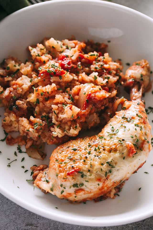 A close-up shot of Crock Pot chicken and rice in a bowl with a sprinkle of chopped parsley on top