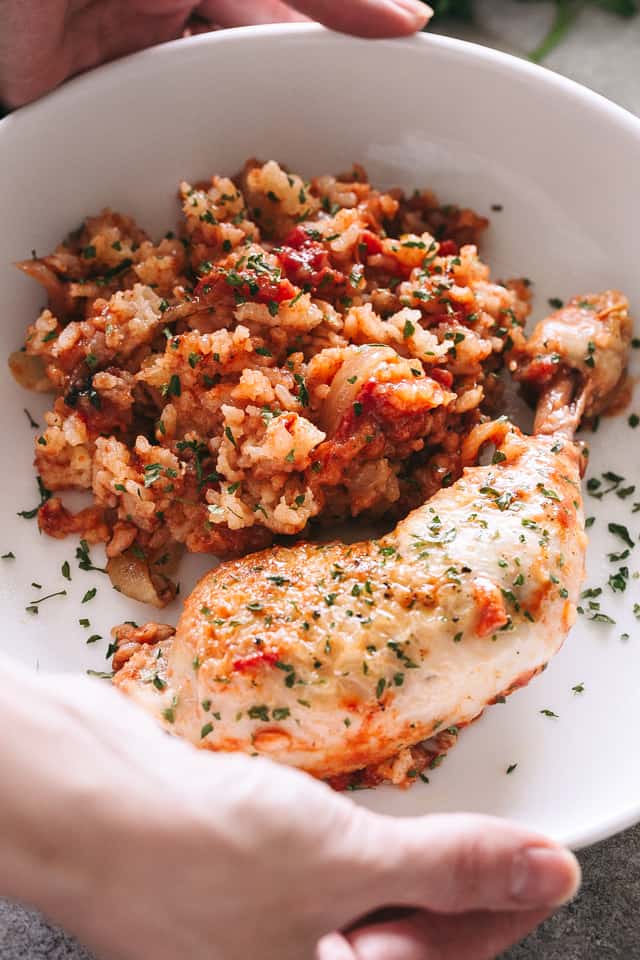 A pair of hands holding a large bowl containing Crock Pot rice and chicken