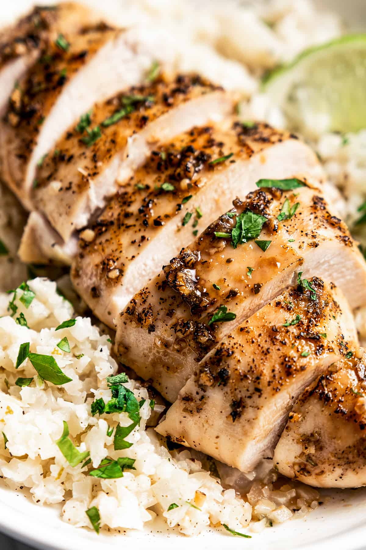 Closeup of sliced baked chicken breast over rice