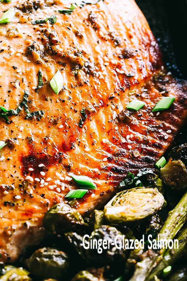 This irresistible baked salmon recipe is simple to prepare & ready in about 30 min! A sweet & spicy ginger-glaze makes this salmon recipe out of this world. #salmon #dinner