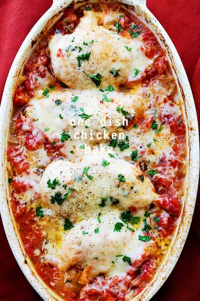 Overhead image of four chicken breasts nestled in tomato sauce and topped with melty cheese.