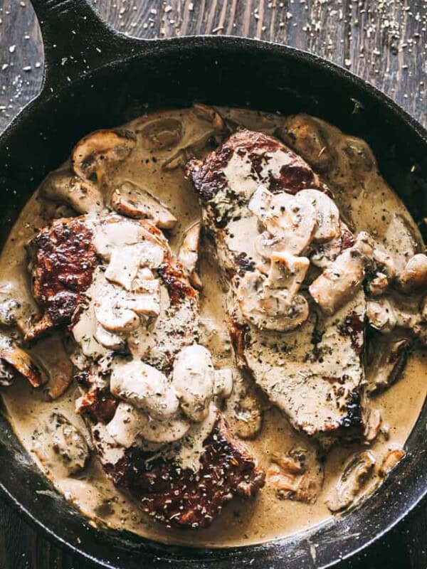 Overhead view of steak with mushroom sauce in a cast iron skillet.