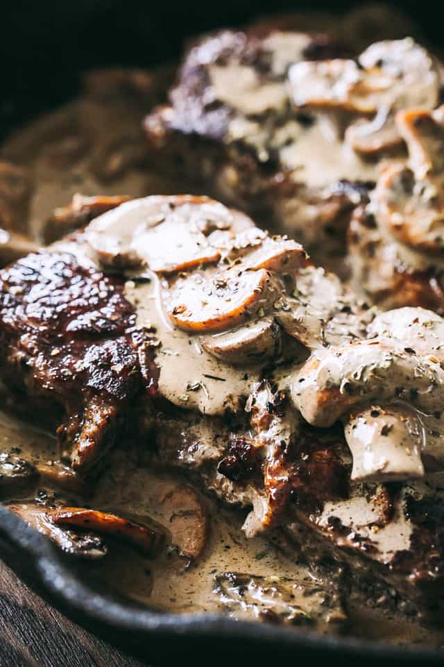 Close up of steak with mushroom sauce in a cast iron skillet.