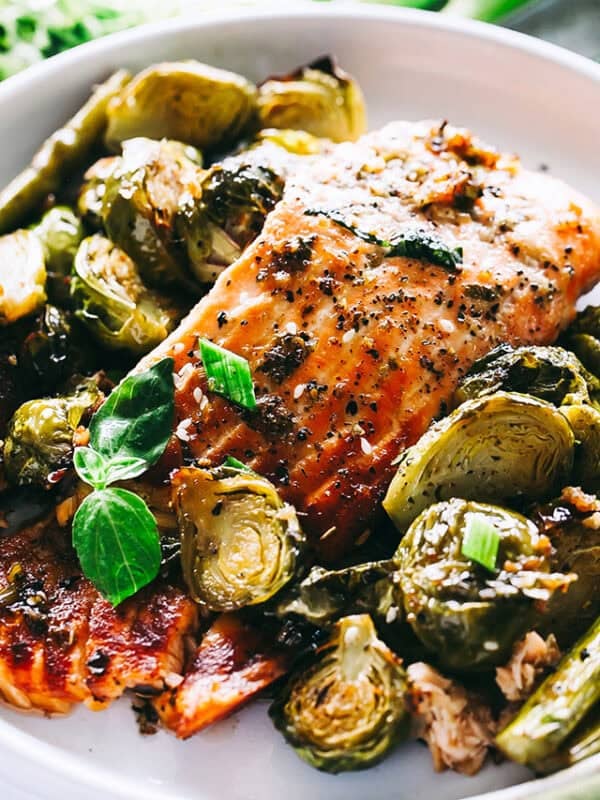 Salmon fillet topped with glaze and served with Brussels sprouts on a plate.