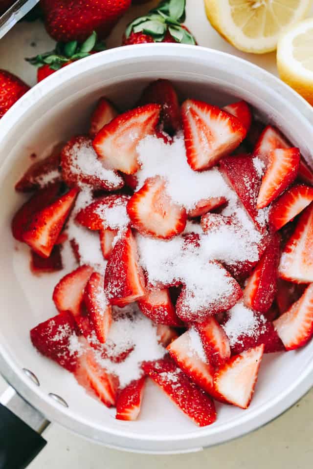 Fresh Strawberries topped with sugar and placed in a saucepan.