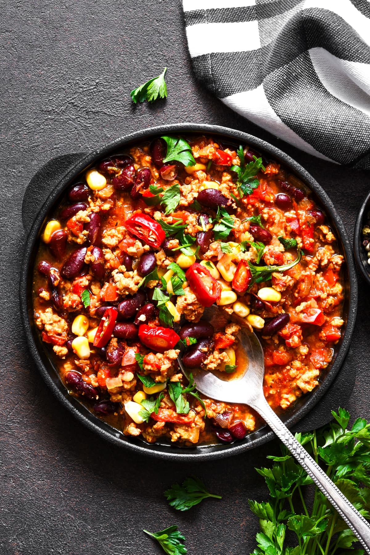 Overhead image of a burrito bowl in a dinner plate topped with chopped peppers and fresh cilantro.