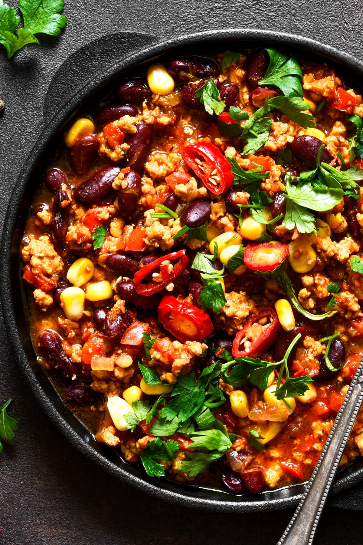 Close-up image of a burrito bowl garnished with fresh cilantro and chopped chiles.