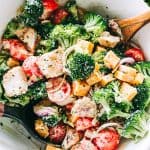 Tossing a broccoli salad with creamy dressing.