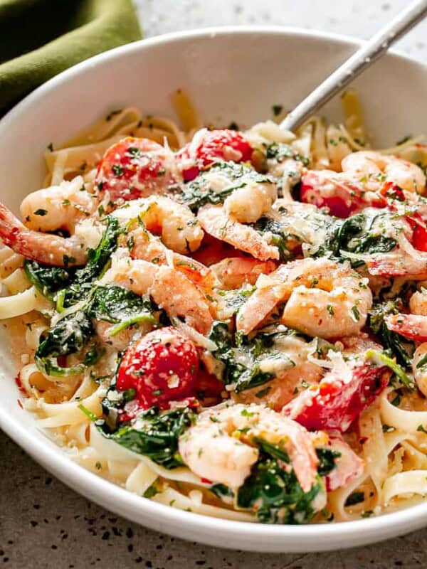 shrimp fettuccine with spinach and tomatoes.