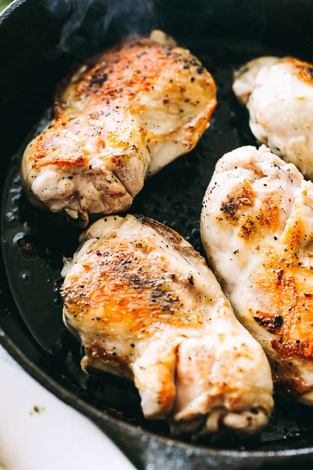 Searing chicken breasts in a skillet.