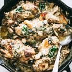 Overhead view of spinach artichoke chicken in a skillet.
