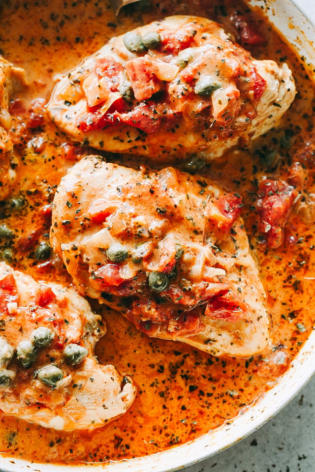 Overhead image of chicken in tomato sauce in a skillet.