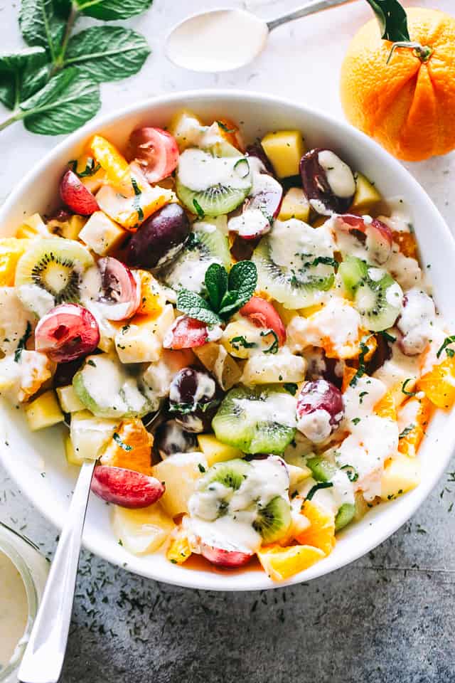 Tropical Fruit Salad served in a bowl and drizzled with a creamy dressing.