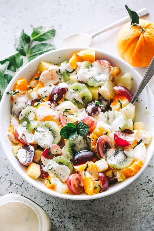 Overhead image of a bowl with Fruit Salad drizzled with Honey Orange Yogurt Dressing.