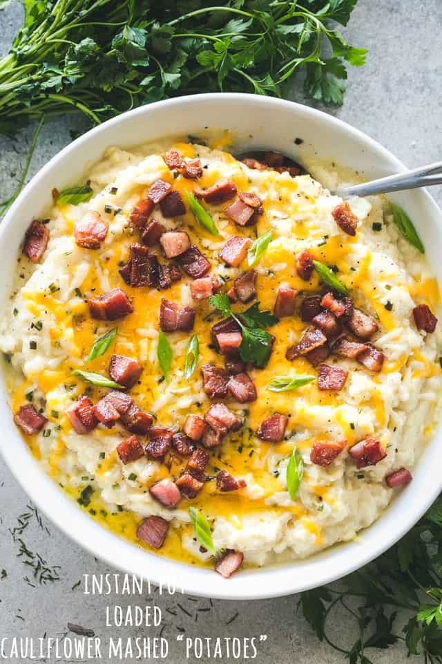 Instant Pot Mashed Cauliflower topped with bacon, melted cheddar cheese, and scallions.