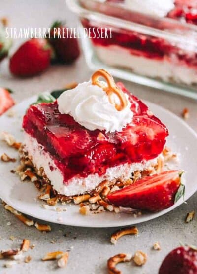Strawberry Pretzel Dessert square served on a dessert dish and garnished with cream.