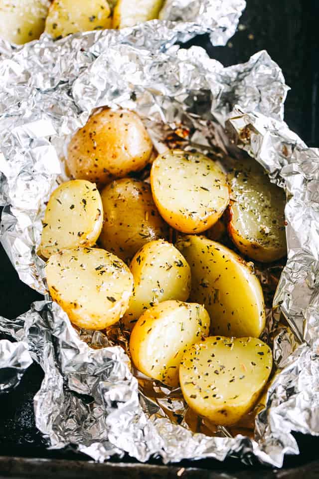 Garlic Herb Grilled Potatoes in Foil - A good dose of garlic, thyme, and rosemary make these potatoes that much more delicious, and the grill gives them just the right amount of crispness and a delicious smoky flavor.