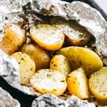 Garlic Herb Grilled Potatoes in Foil - A good dose of garlic, thyme, and rosemary make these potatoes that much more delicious, and the grill gives them just the right amount of crispness and a delicious smoky flavor.