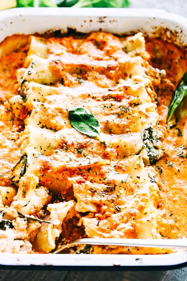 Tender cannelloni tubes are stuffed with cheesy chicken, ricotta, and spinach, then baked in creamy sauce in this easy family dinner recipe! Chicken cannelloni with cream sauce in a casserole dish.