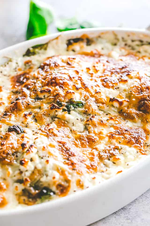 Cheesy Chicken Spinach Bake - Tender baked chicken breasts topped with creamy spinach and melty cheese. A one-pot low carb dinner that's perfect for those busy weeknights!