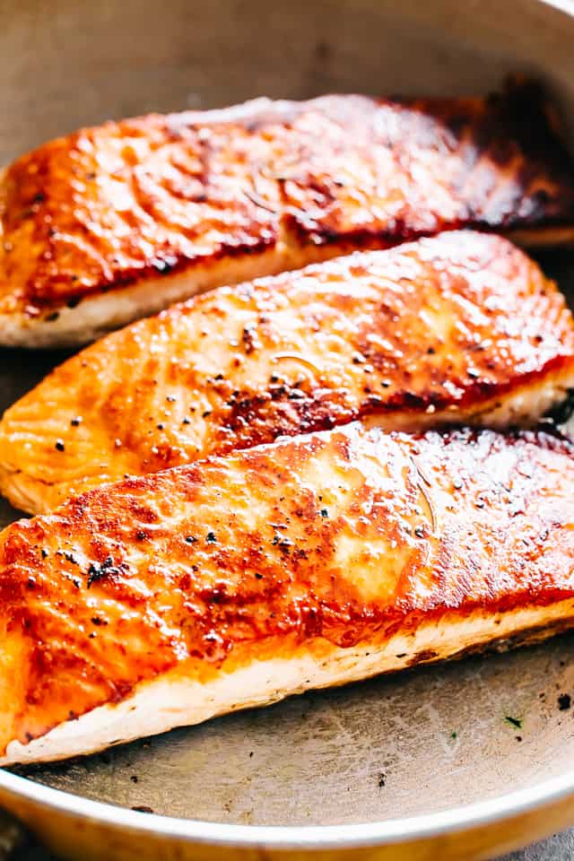 Searing salmon in a skillet.