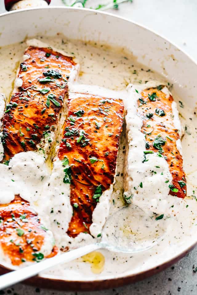 Pan Seared Salmon with Lemon Garlic Cream Sauce in a skillet.