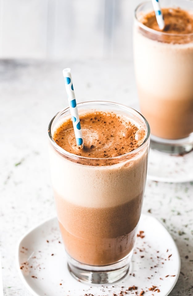 Two tall drinking glasses filled with coffee Frappe.