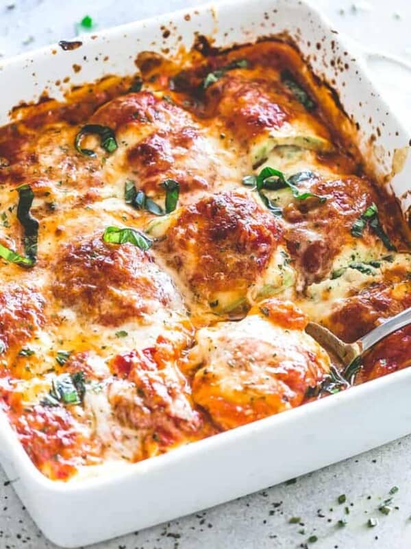 Zucchini rollups arranged and baked in a white baking dish.