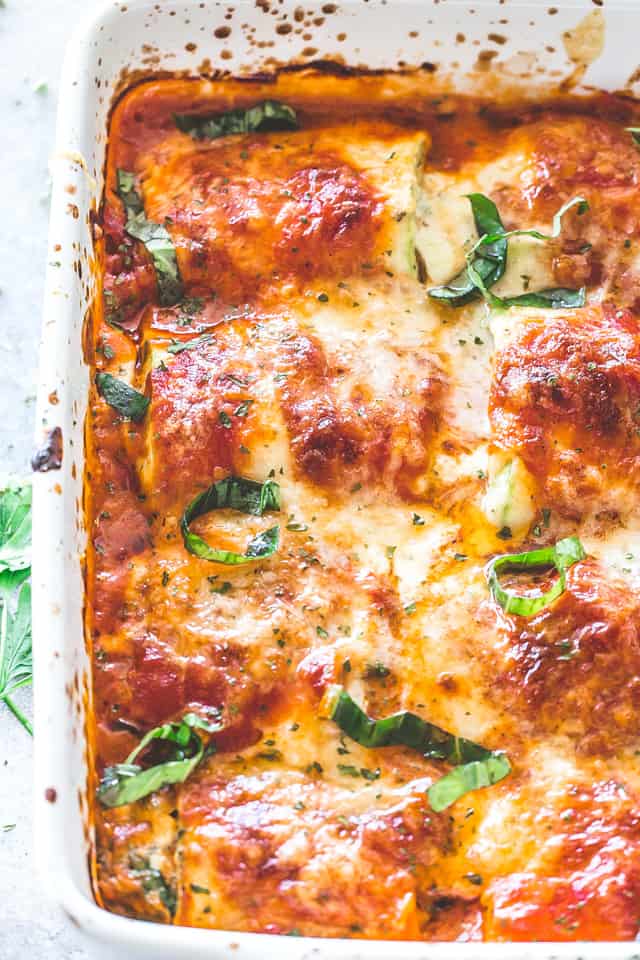 Overhead photo of zucchini lasagna rollups bundles in a dish.