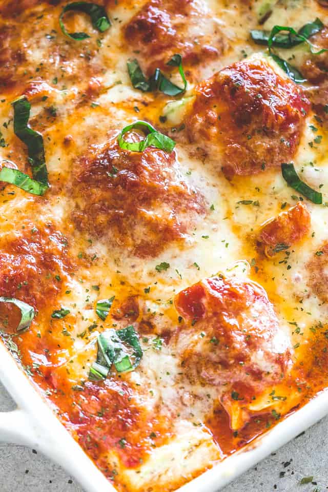 Close-up photo of zucchini lasagna rollups in a dish.