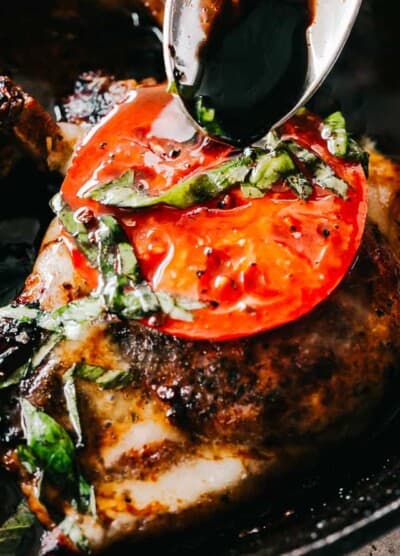 Caprese Pork Chops - Seared juicy caprese pork chops marinated in a garlicky balsamic glaze and topped with sweet tomatoes, melted mozzarella cheese, and fresh basil!