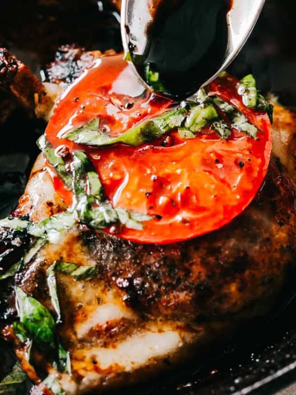 Caprese Pork Chops - Seared juicy caprese pork chops marinated in a garlicky balsamic glaze and topped with sweet tomatoes, melted mozzarella cheese, and fresh basil!