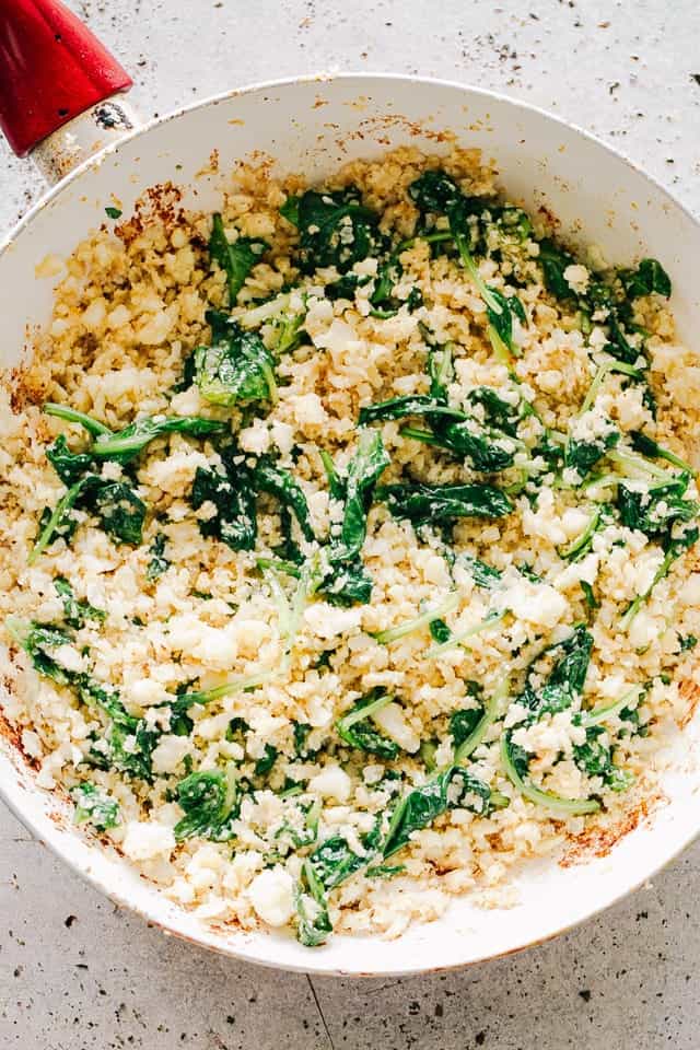 Garlic Butter Cauliflower Rice with Spinach in a skillet.