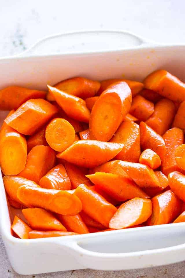 Chunks of carrots arranged in a white baking dish.