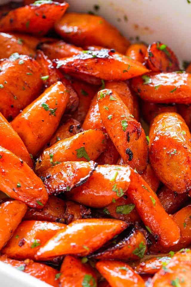 Photo of chopped chunks of roasted carrots tossed with a honey garlic butter sauce.