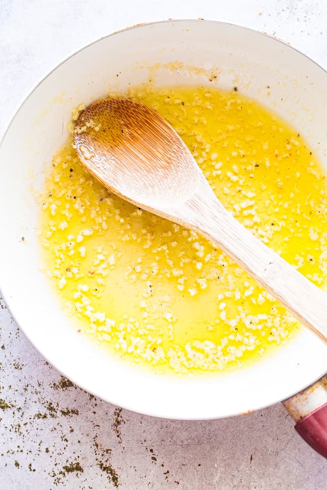 Cooking butter and minced garlic in a skillet.