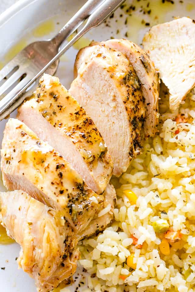 Sliced Chicken Breast served alongside rice topped with corn.