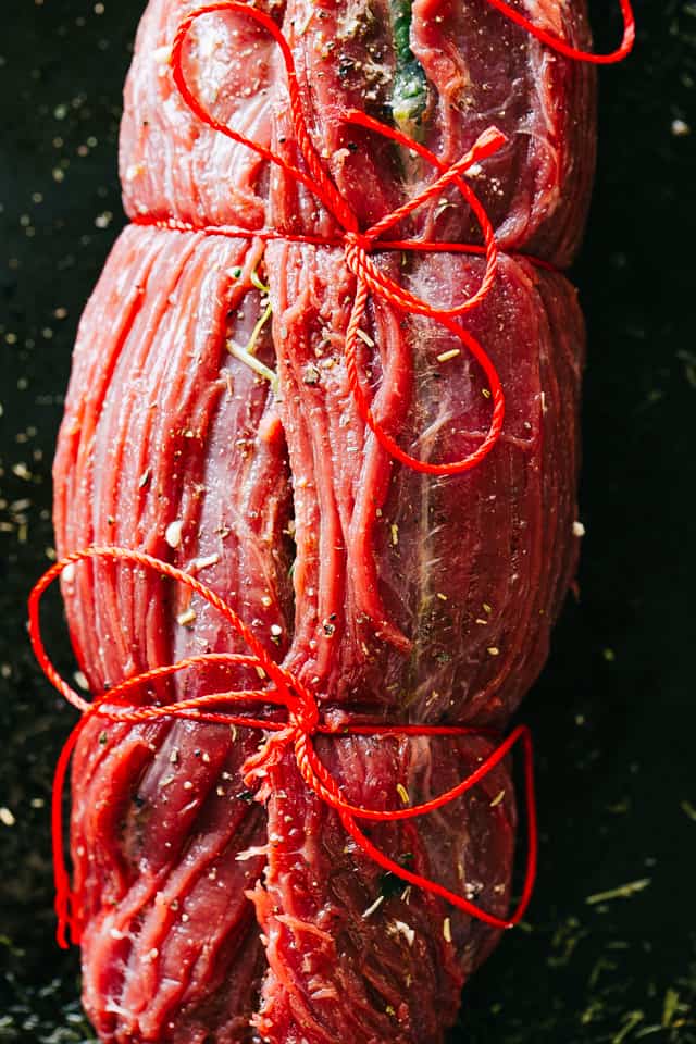 Stuffed and rolled flank steak tied with kitchen twine.